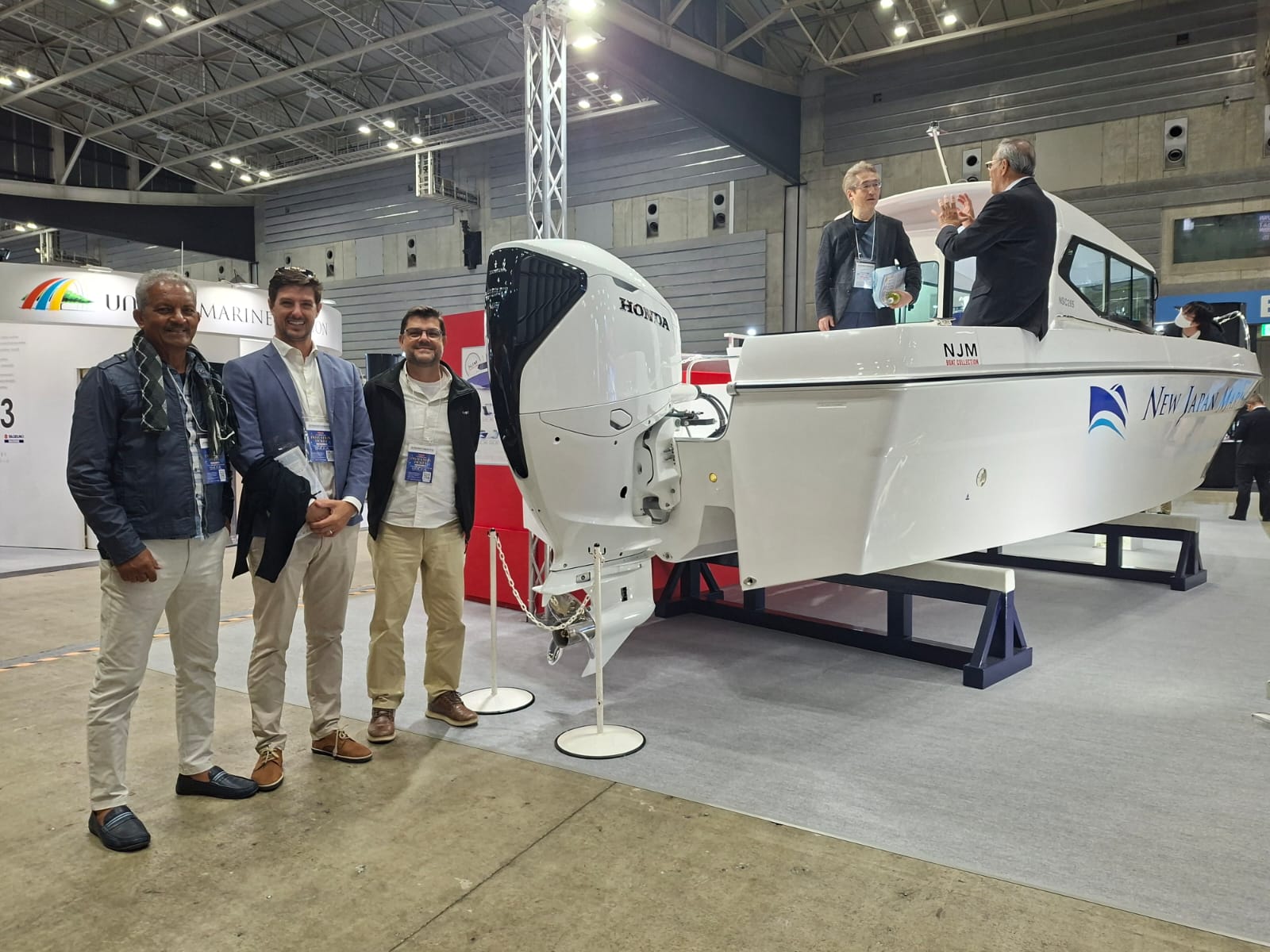 SECO MARINE team beside a Honda outboard at the Japan Boat Show